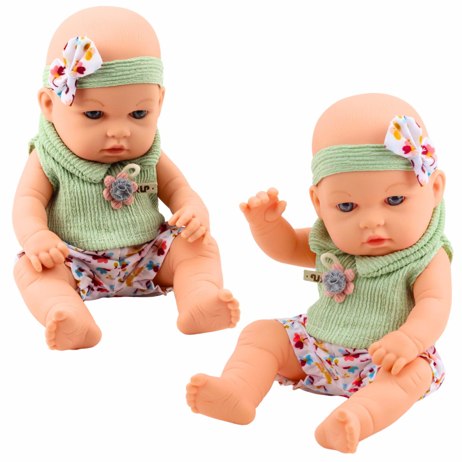 Babydukke med grønt blomsteroutfit og sløjfebånd